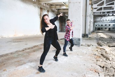 Erkek ve kız eski endüstriyel binada hip-hop dansı yapıyorlar. Genç çift sanat dansı. Sokak şehir yaşam tarzı.