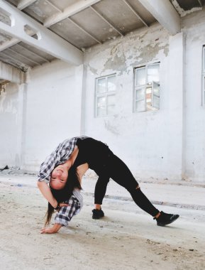 Breakdance akrobatik elementleri sergiler. Eski endüstriyel binada hip-hop yapan kız. Genç kız sanat dansı. Sokak şehir yaşam tarzı.