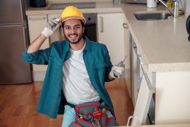 Üniformalı erkek işçi mutfakta mobilya monte ediyor. Tamir konsepti. Yüksek kalite fotoğraf