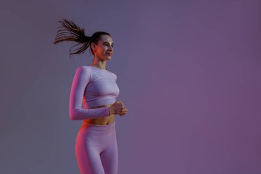 Athletic active woman jumping on studio background. Dynamic movement