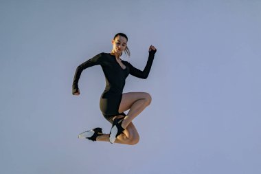 Athletic active woman jumping on studio background . Dynamic movement