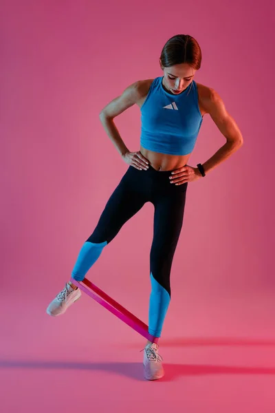 Fitness Γυναίκα Στέκεται Και Τέντωμα Ελαστική Ζώνη Πόδια Στο Φόντο — Φωτογραφία Αρχείου