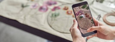 Kendine güvenen kadın akıllı telefonuyla fotoğraf çekiyor.