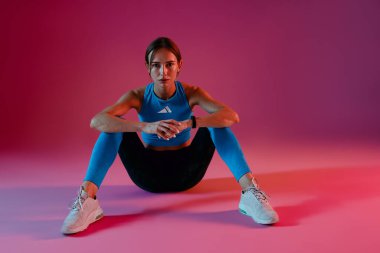 Moda sporlarındaki spor mankeni stüdyo arka planında rahatlıyor. Yüksek kalite fotoğraf