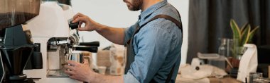 Barista kahve makinesinde buhar akışını düzenliyor, sütü buharla ısıtıyor.