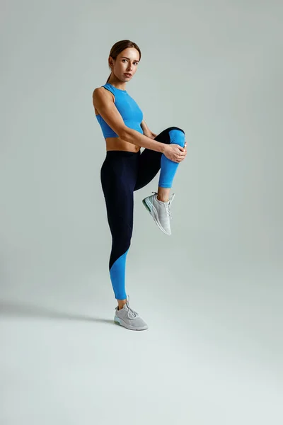 有吸引力的女运动员拉长腿 在演播室的背景下进行体操训练 — 图库照片