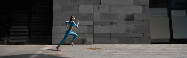 stock image Beautiful fit young woman jogger is running outdoors