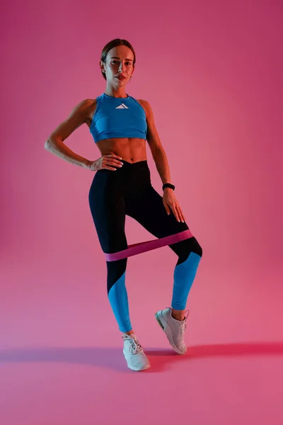 Αθλητική Γυναίκα Προπονεί Πόδια Ελαστικό Ιμάντα Γυμναστικής Στο Φόντο Στούντιο — Φωτογραφία Αρχείου