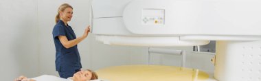 Radyoloji uzmanı MRI ya da CT taramasını hasta işlemleri ile kontrol ediyor. Yüksek Teknoloji Tıbbi Ekipmanı