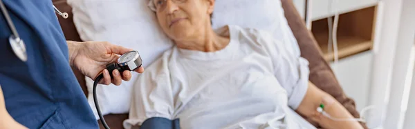 現代クリニックに向かう先輩女性の血圧を医師がチェック 高品質の写真 — ストック写真
