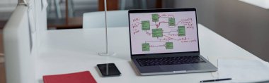 Office desk with laptop, phone and documents on table in modern office. High quality photo