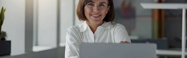 stock image Smiling european business woman working laptop while sitting in cozy cafe. Blurred background