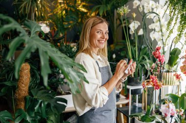 Çiçekçi kadın siparişleri ve müşteri bilgilerini çiçekçide deftere yazıyor. Yüksek kalite fotoğraf