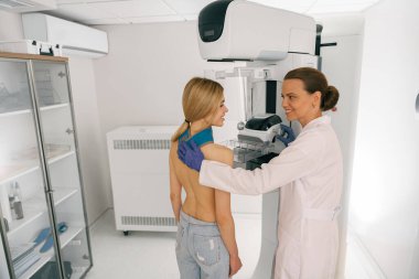 Kadın radyolog, göğüs kanserini kontrol etmek için mammogram röntgeni çekiyor. Yüksek kalite fotoğraf