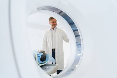 Radyoloji uzmanı MRI ya da CT taramasını hasta işlemleri ile kontrol ediyor. Yüksek Teknoloji Tıbbi Ekipmanı