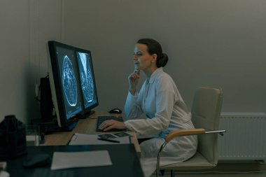 Kadın doktor nörolog hastanede beyin taraması görüntülerini analiz ediyor. Yüksek kalite fotoğraf