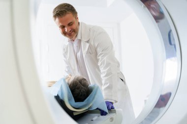 Radyoloji uzmanı MRI ya da CT taramasını hasta işlemleri ile kontrol ediyor. Yüksek Teknoloji Tıbbi Ekipmanı