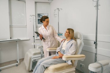 Hastanede seruma hazırlarken hastayla konuşan bir doktor. Yüksek kalite fotoğraf