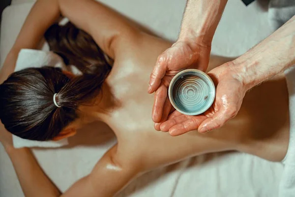 Massaggiatore Uomo Possesso Ciotola Con Olio Infuso Erbe Calde Massaggio — Foto Stock