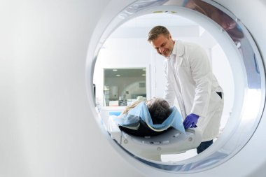 Radyoloji uzmanı MRI ya da CT taramasını hasta işlemleri ile kontrol ediyor. Yüksek Teknoloji Tıbbi Ekipmanı