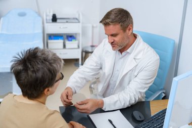 Estetik cerrah, gelecekteki ameliyatlar için kadın göğüs implantı örnekleri gösteriyor. Yüksek kalite fotoğraf
