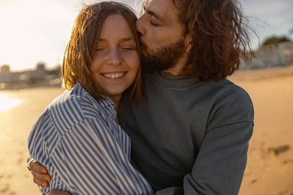 stock image Handsome couple in love hugging while walking along the beach on sunny day. High quality photo