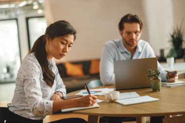 Çalışma günlerinde modern ortak çalışma alanındaki odaklanmış iş adamları 