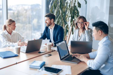 Modern ofiste panoramik görüşlü yaratıcı iş adamları proje üzerinde çalışıyor. Takım çalışması konsepti