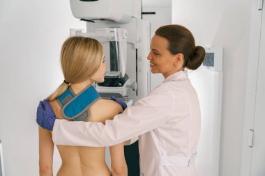 Woman doing mammogram x ray for breast cancer prevention screening at hospital clipart