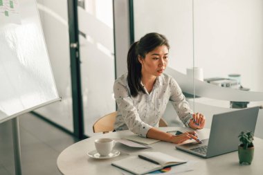 Modern çalışma masasında otururken dizüstü bilgisayarda çalışan kadın girişimci. Yüksek kalite fotoğraf