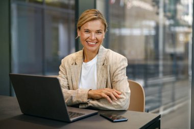 Modern çalışma masasında otururken dizüstü bilgisayarda çalışan kadın satış müdürü. 