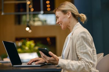 Modern çalışma masasında otururken dizüstü bilgisayarda çalışan kadın satış müdürü. 