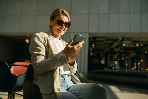 Mujer Negocios Sonriente Gafas Usar Teléfono Mientras Está Sentado Moderno Fotos de stock