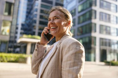 Modern ofis arka planında duran kadın yöneticinin telefon konuşmasını kapat.