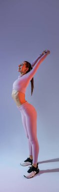 Sporty woman doing warm-up before training session in gym on studio background. High quality photo