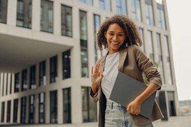 Mola sırasında ofis arka planında dizüstü bilgisayarı olan şık bayan yönetici.