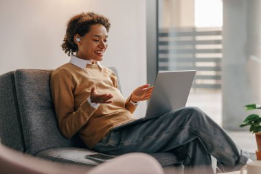 Pozitif kadın serbest çalışan gün boyunca rahat bir iş yerinde otururken online toplantı yapıyor.