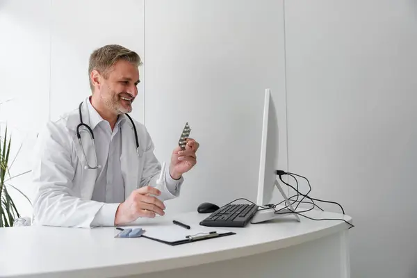 Doctor conducts online consultation with patient and showing pills to him. High quality photo