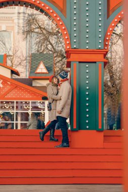 Şenlik sahnesinde, tutkulu bir çift, bir Noel festivalinde romantizmin özünü yakalıyor.