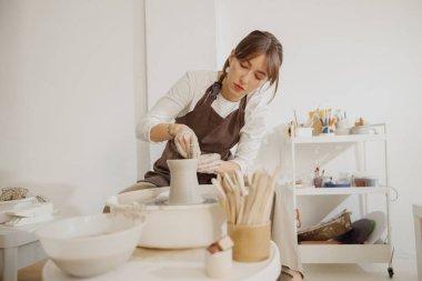 Çömlek atölyesinde killik şekillendiren profesyonel kadın zanaatkar. Seramik sanat konsepti