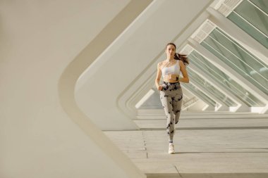 Spor giyim sektöründe genç bir kadın modern binalarda çalışıyor. Etkin yaşam tarzı kavramı