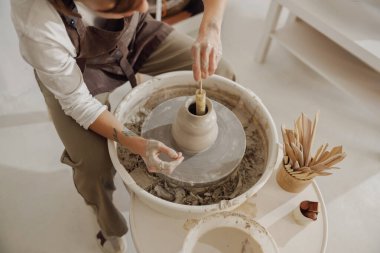 Çömlek atölyesinde kil kasesini şekillendiren zanaatkârların ellerine yakın çekim. Çömlek sanatı ve yaratıcılığı