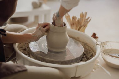 Çömlek çarkının üzerinde profesyonel çömlekçi kalıpları olan ellere yakın durun. Seramik sanat konsepti
