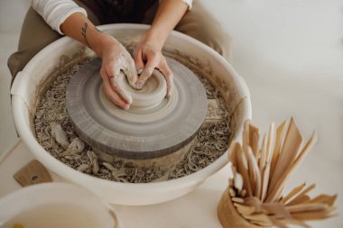 Çömlek atölyesinde kil kasesini şekillendiren zanaatkârların ellerine yakın çekim. Çömlek sanatı ve yaratıcılığı