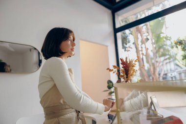 Kahve dükkanında tezgahta duran profesyonel bir baristaydı ve siparişleri alıyordu. Yüksek kalite fotoğraf