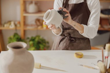 Çömlek atölyesindeki işlenmemiş kil vazo ile kadın seramistiği işini kapat. Yüksek kalite fotoğraf