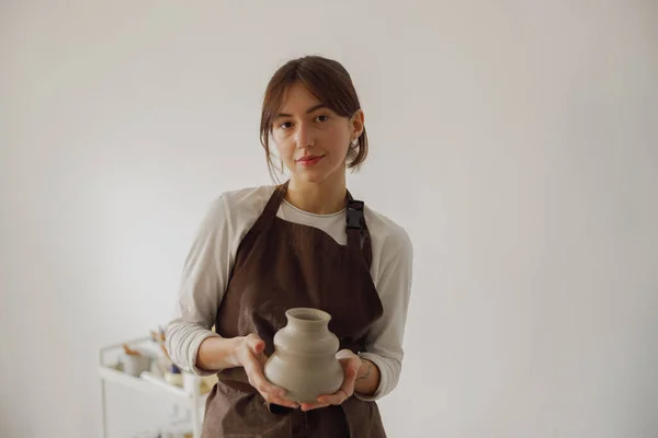 Confident entrepreneur crafts woman in pottery studio looking at camera