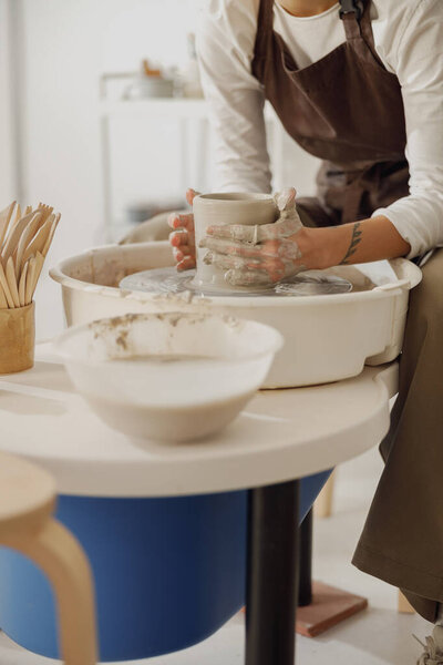 Close up of artisans hands shaping clay bowl in pottery studio. Pottery art and creativity