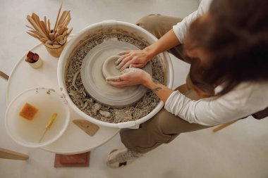 Çömlek atölyesinde kil kasesini şekillendiren zanaatkârların ellerine yakın çekim. Çömlek sanatı ve yaratıcılığı