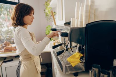 Kahve makinesinde kahve yapan profesyonel bayan barista kafede çalışıyor. Yüksek kalite fotoğraf